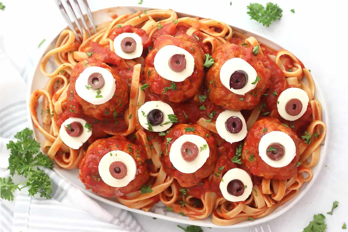 Meatball 'eyeballs' served on pasta and sauce and garnished with parsley.