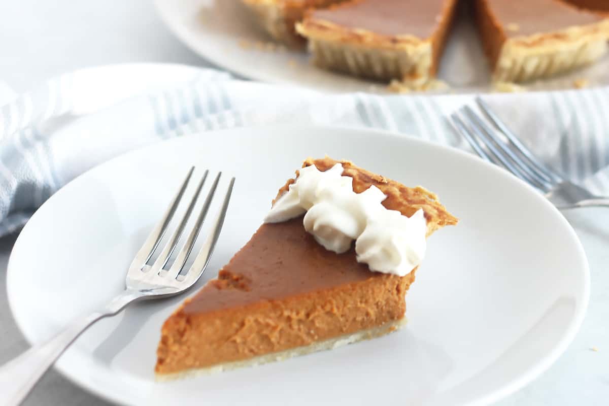 A slice of fireball whiskey pumpkin pie on a plate with a fork.