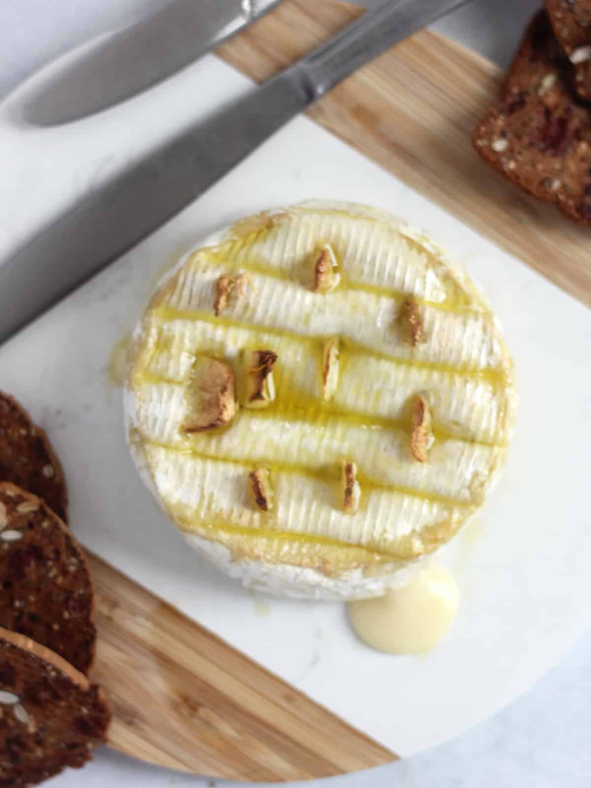 Air fryer baked camembert with slices of garlic.