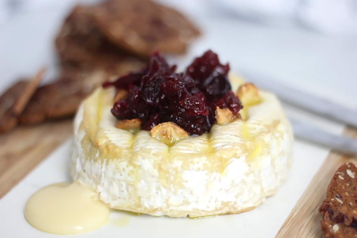 Air fryer camembert topped with garlic and cranberry sauce.