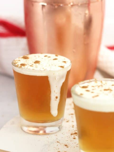 A whisky shot with cream running down the glass.