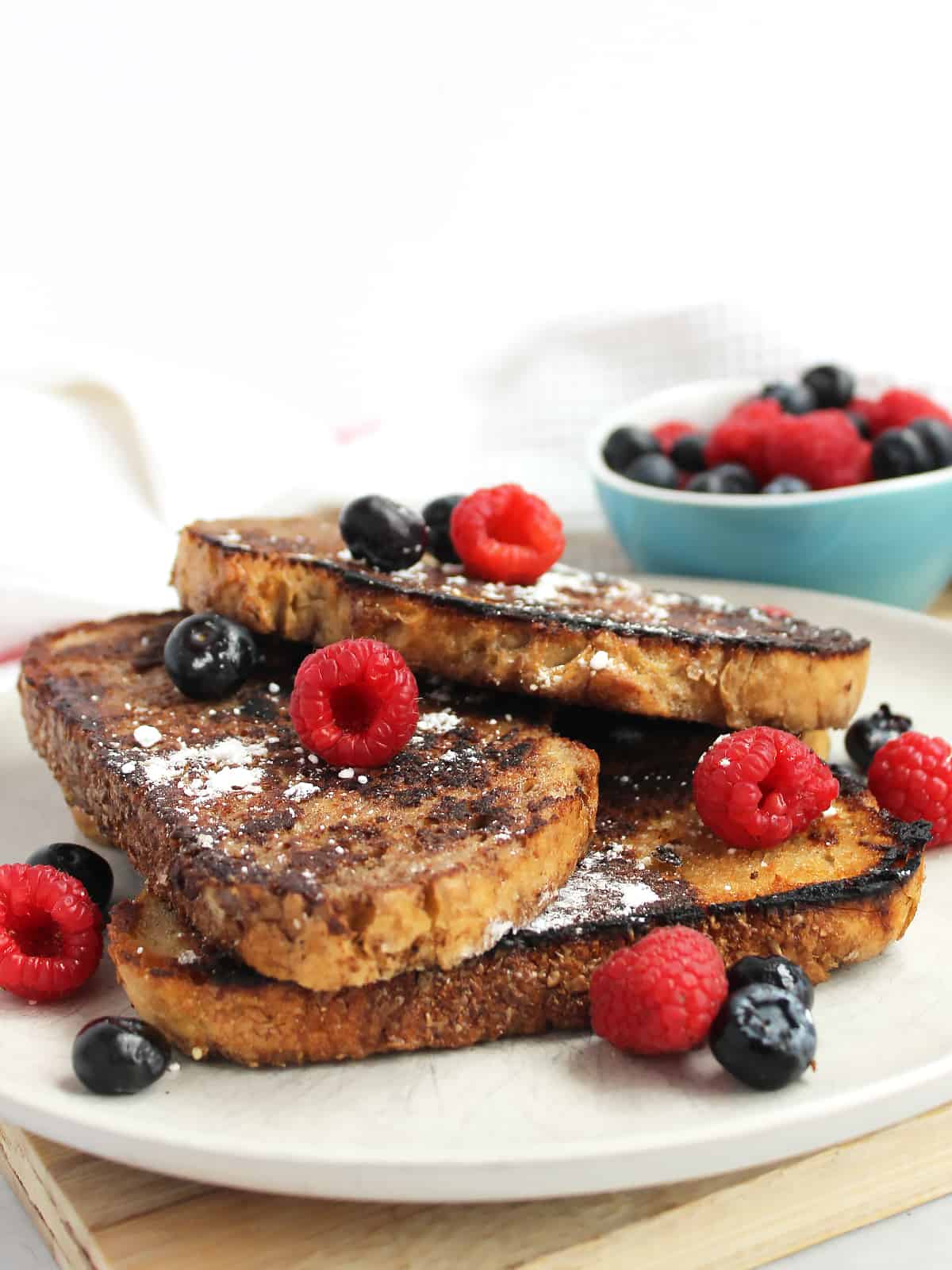 French toast served on a plate with powdered sugar and fresh berries.