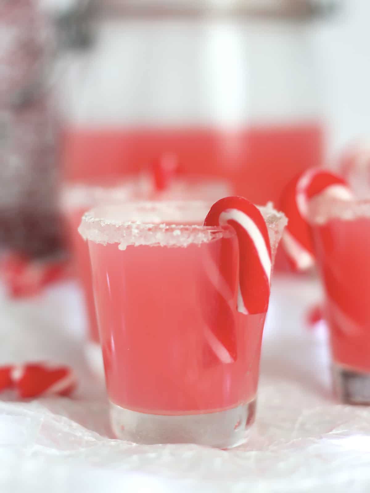 A mini candy cane in a pink vodka shot.