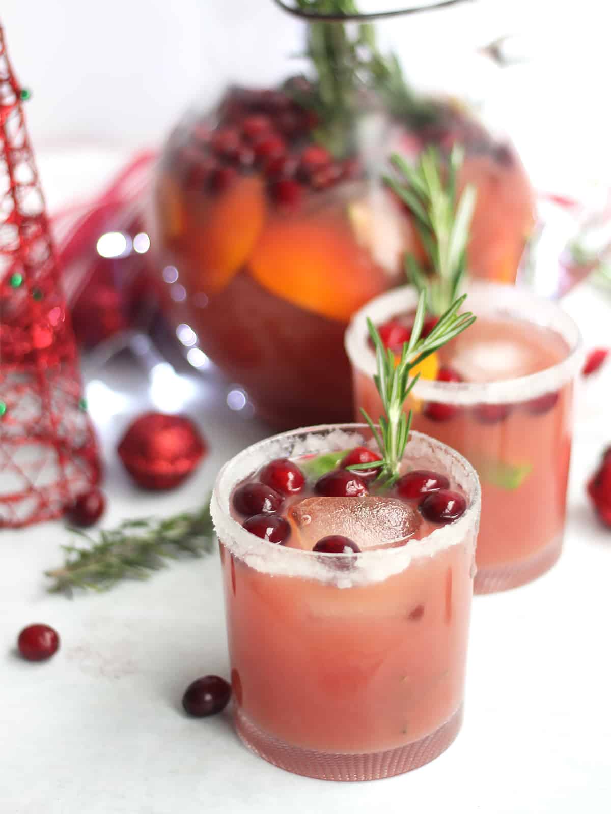 Cranberry, orange and ginger mocktails with ice and fresh rosemary.