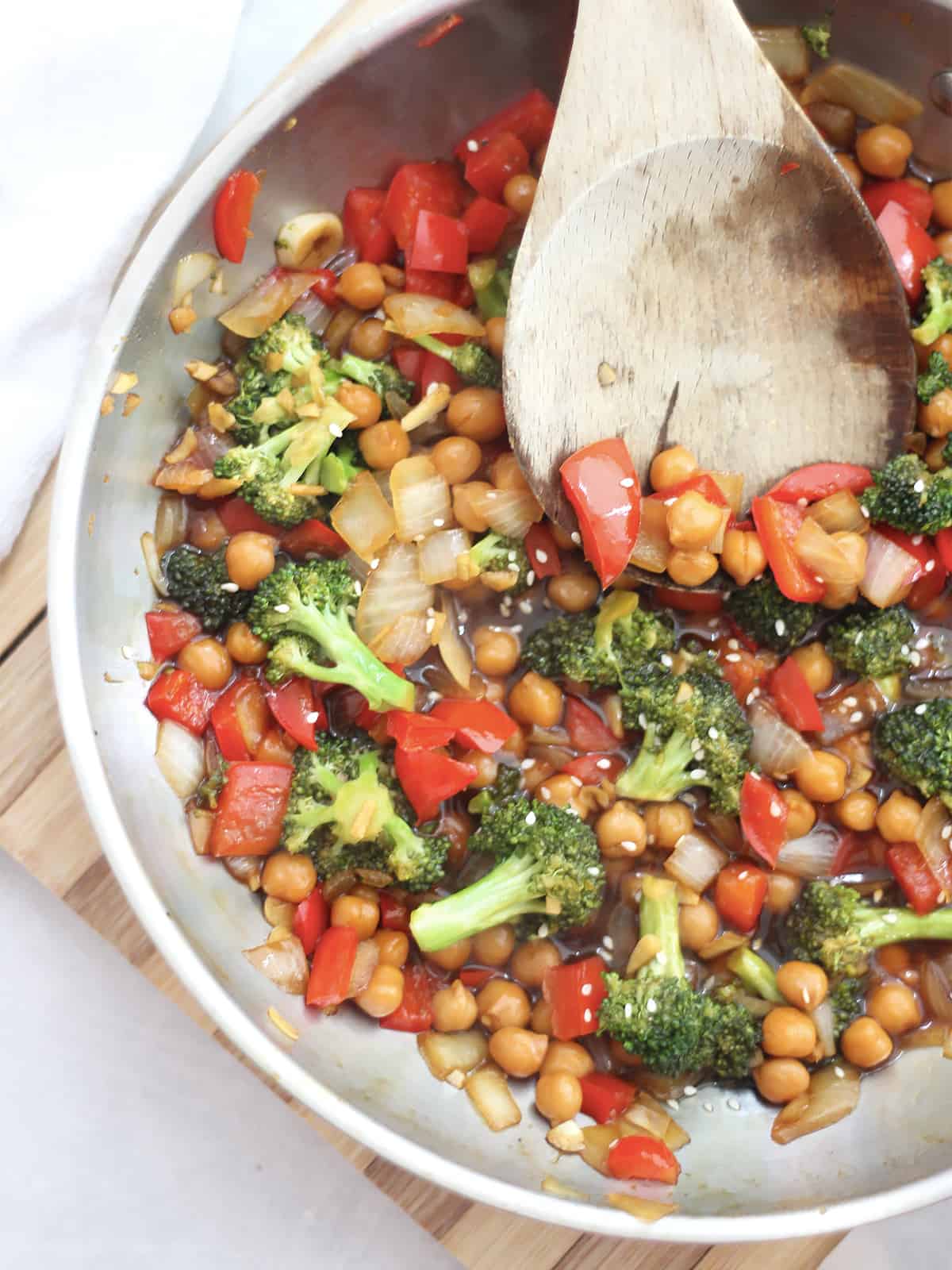 Overhead shot of chickpeas and vegetables in a Chinese sauce in a skillet.