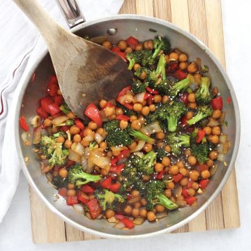 Chickpea teriyaki in a silver skillet with a wooden spoon.