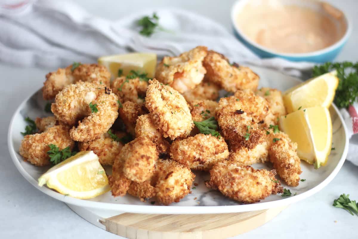Spicy breaded shrimp garnished with fresh parsley and lemon wedges.