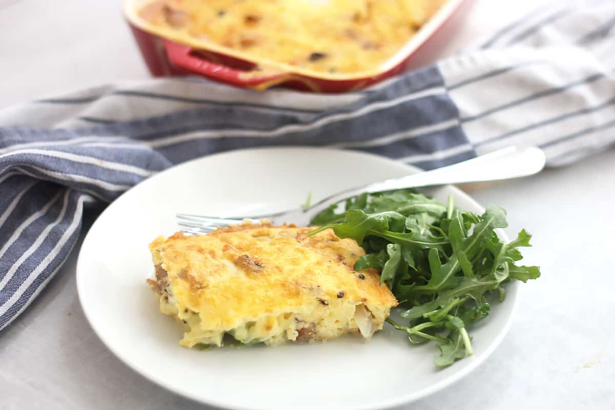 Sausage and egg casserole served with a side salad.