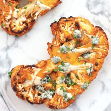 A buffalo cauliflower steak topped with blue cheese and chives.
