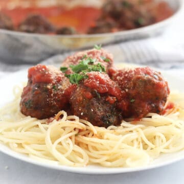 Lamb meatballs with tomato sauce served over spaghetti.