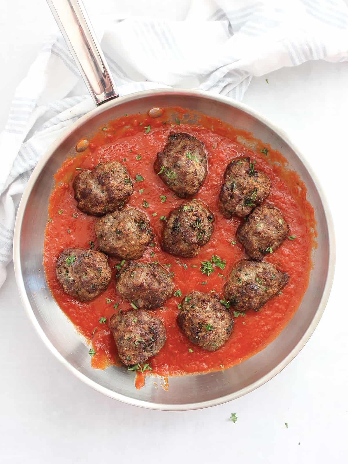 Lamb meatballs in a skillet with tomato sauce.