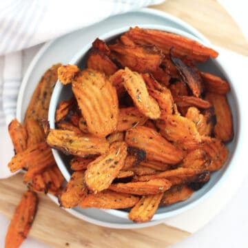 Air fryer carrot chips in a small blue serving bowl.