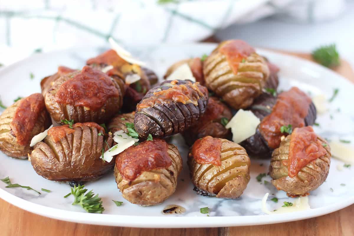 Baked baby hasselbacks on a serving plate.