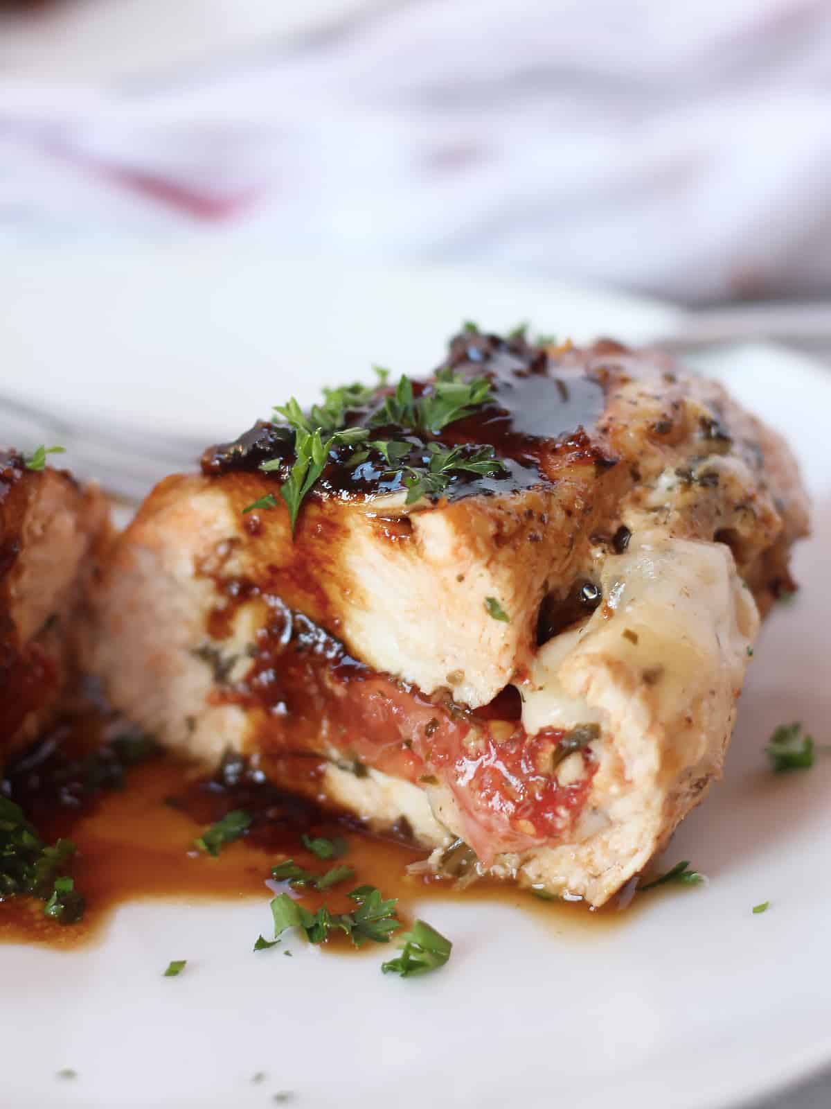 Balsamic reduction spooned over caprese stuffed chicken breasts.