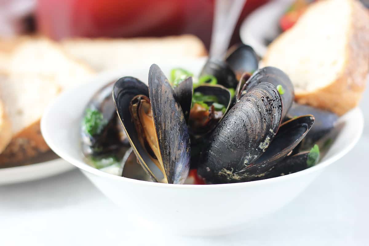 Mussels served in Thai coconut milk garnished with green onions.