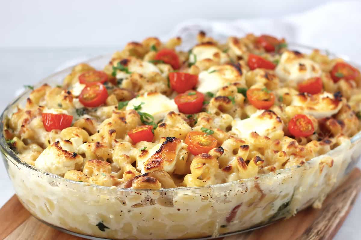 Tomato and goats cheese pasta bake in a glass baking dish.