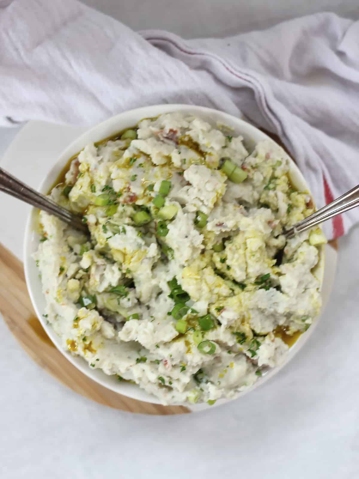 Two serving spoons in a bowl of blue cheese mash.