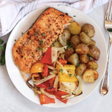 Air fried, salmon, vegetables and potatoes served on a plate with a garnish of fresh parsley.