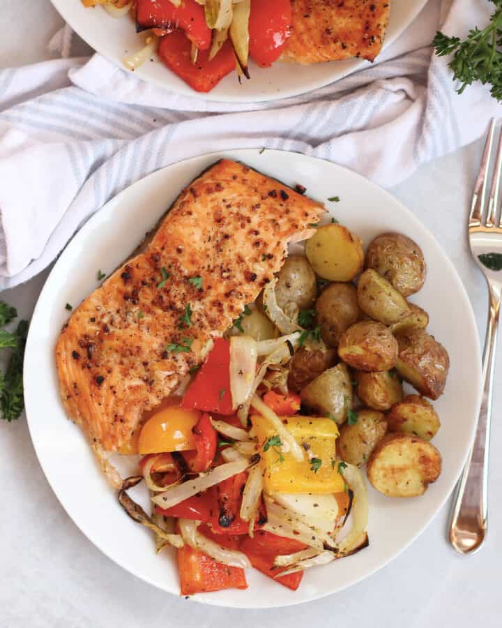 Air fried salmon, vegetables and potatoes served on a white plate.