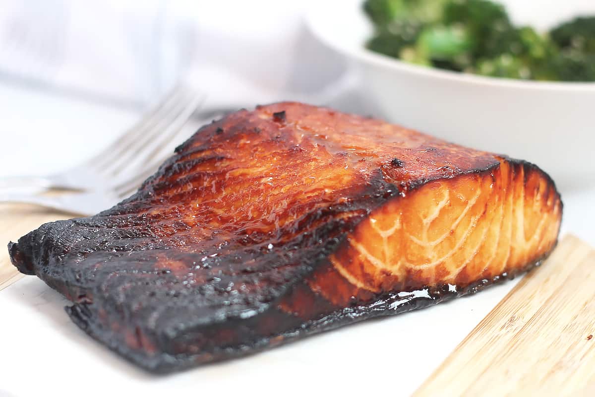 Air fryer honey soy salmon on a wooden chopping board.