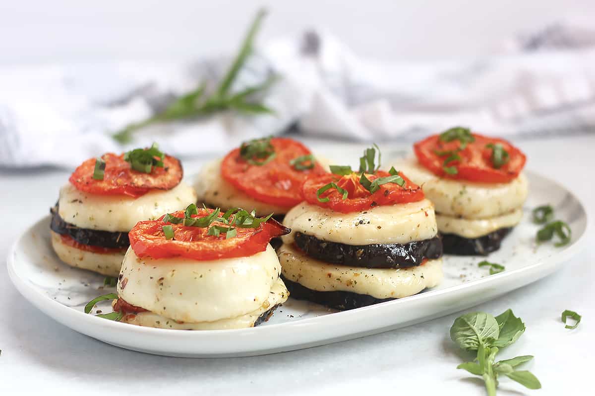 Eggplant rounds stacked with roasted tomato and mozzarella.