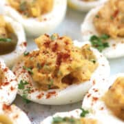 An egg white stuffed with seasoned egg yolk, and garnished with fresh herbs and spices.