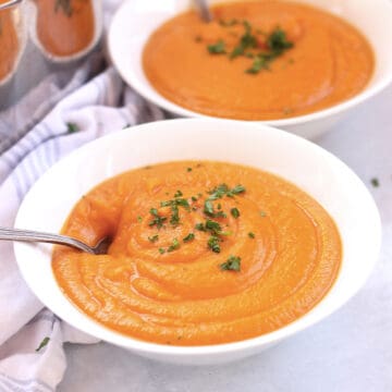A spoon in a bowl of sweet potato and butternut squash soup.
