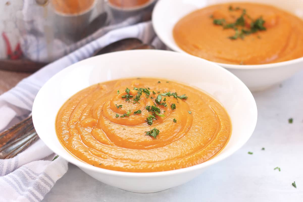 Sweet potato and butternut squash soup served in two white bowls.