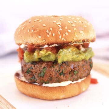 A Mexican burger with toppings in a bun.