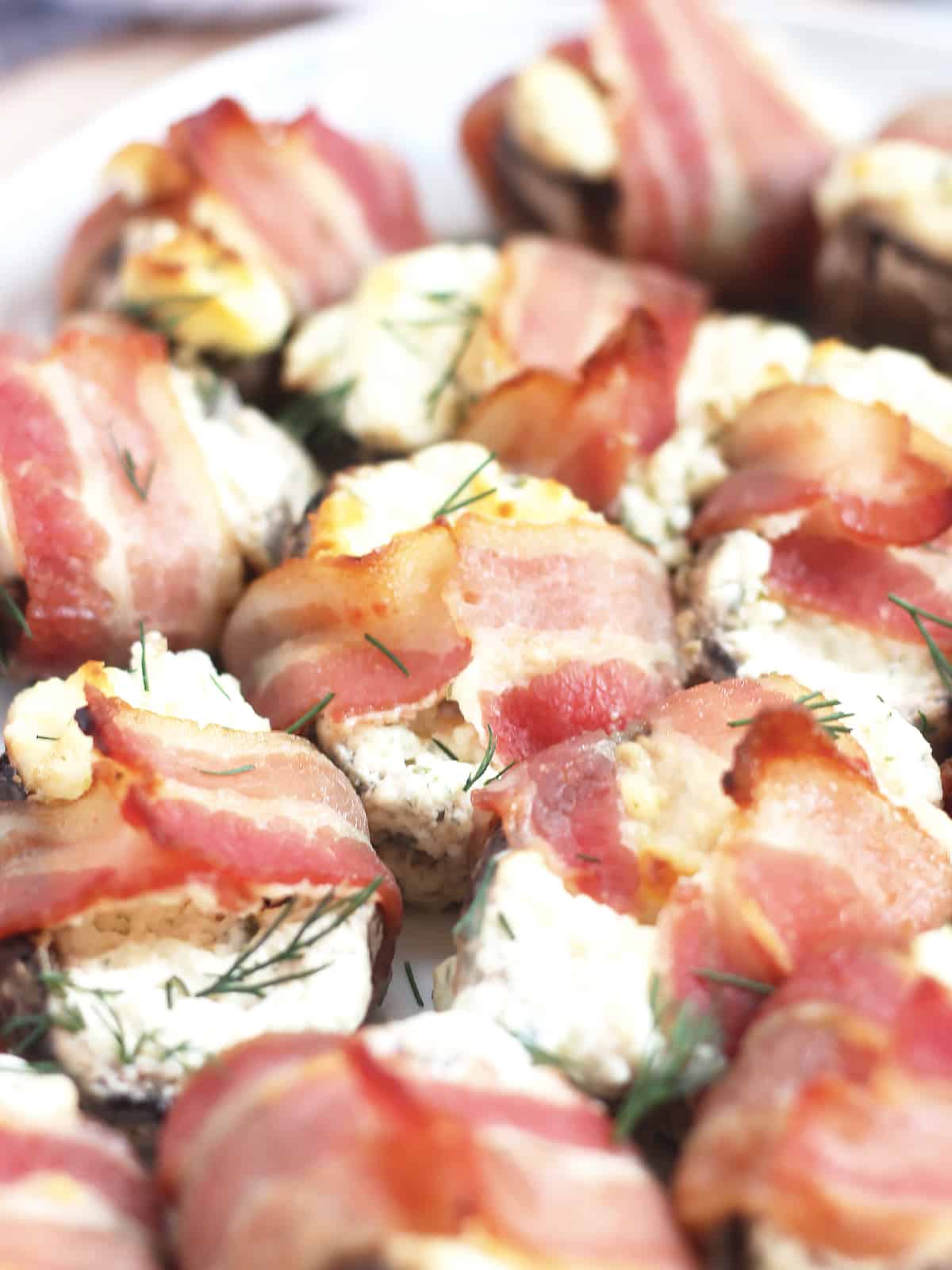 Cheese stuffed mushrooms wrapped in strips of bacon.
