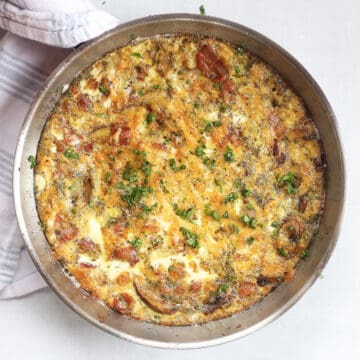 Bacon, mushroom and cheese frittata in a silver skillet.