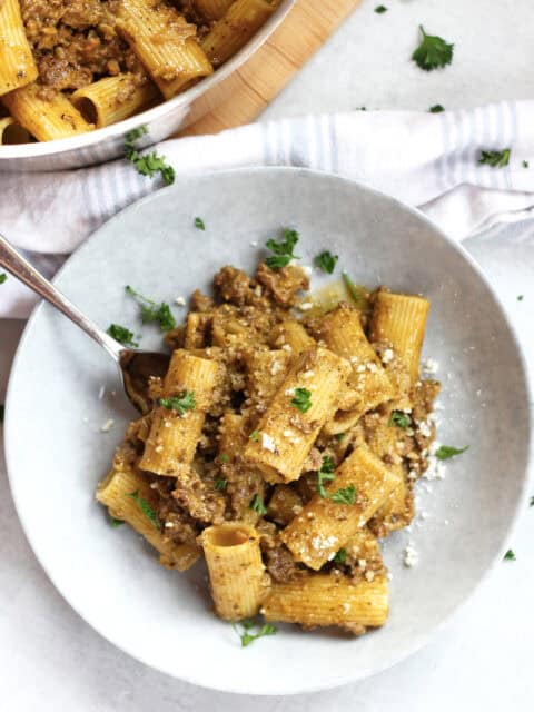 Creamy pesto beef pasta served in a bowl with a fork.