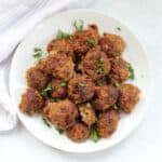 Meatballs garnished with fresh parsley.