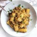 A fork in a bowl of creamy pesto beef pasta.