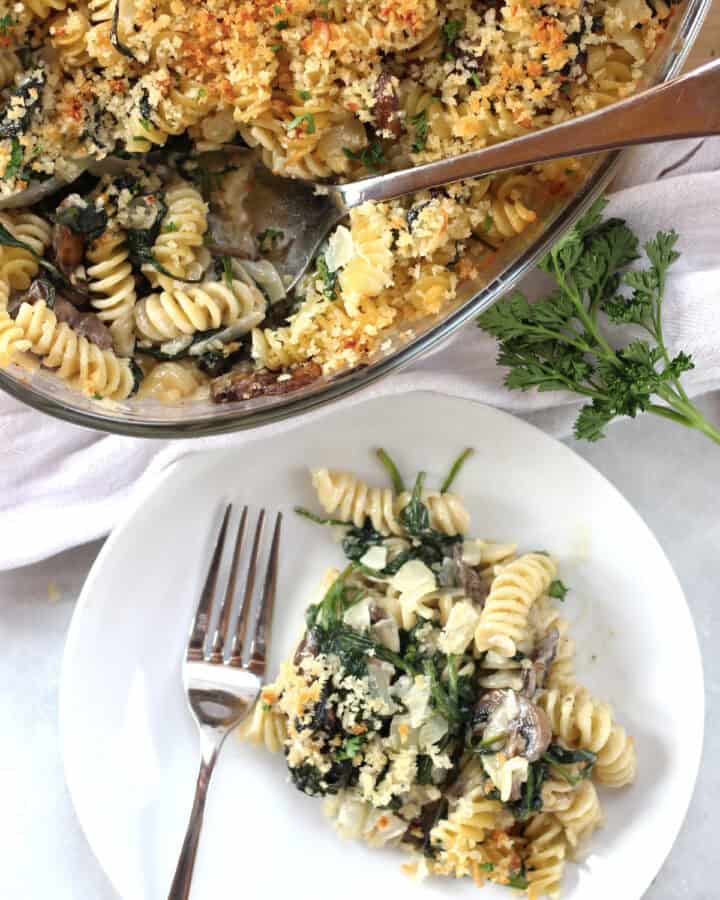A pasta bake in a glass dish and some served onto a plate.