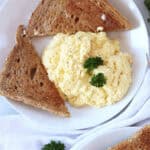 Buttered toast served with cheesy scrambled eggs.