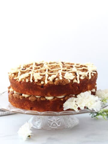A two layered cake served on a glass cake stand.