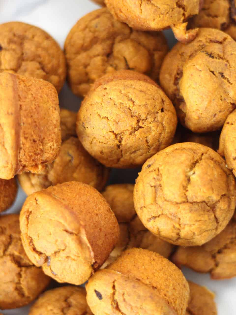 Baked muffins piled on a plate.