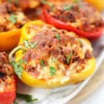 A yellow stuffed bell pepper topped with melted cheese.
