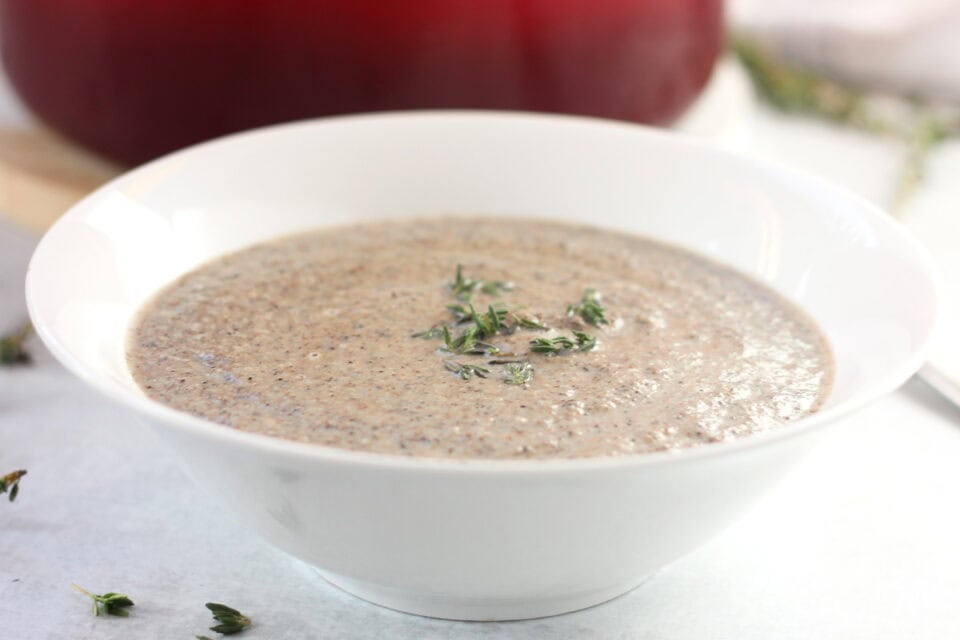 Mushroom and garlic soup garnished with fresh herbs.