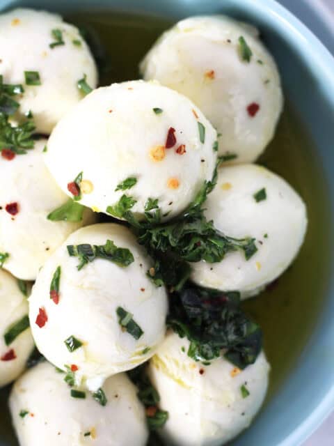 cheese balls marinated with fresh herbs and red pepper flakes.