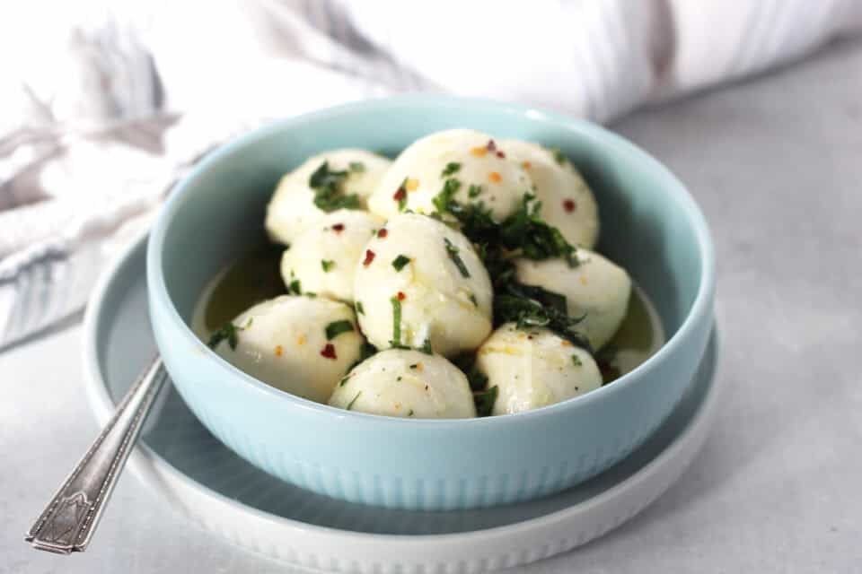 Bocconcini balls in a small serving bowl on a plate.