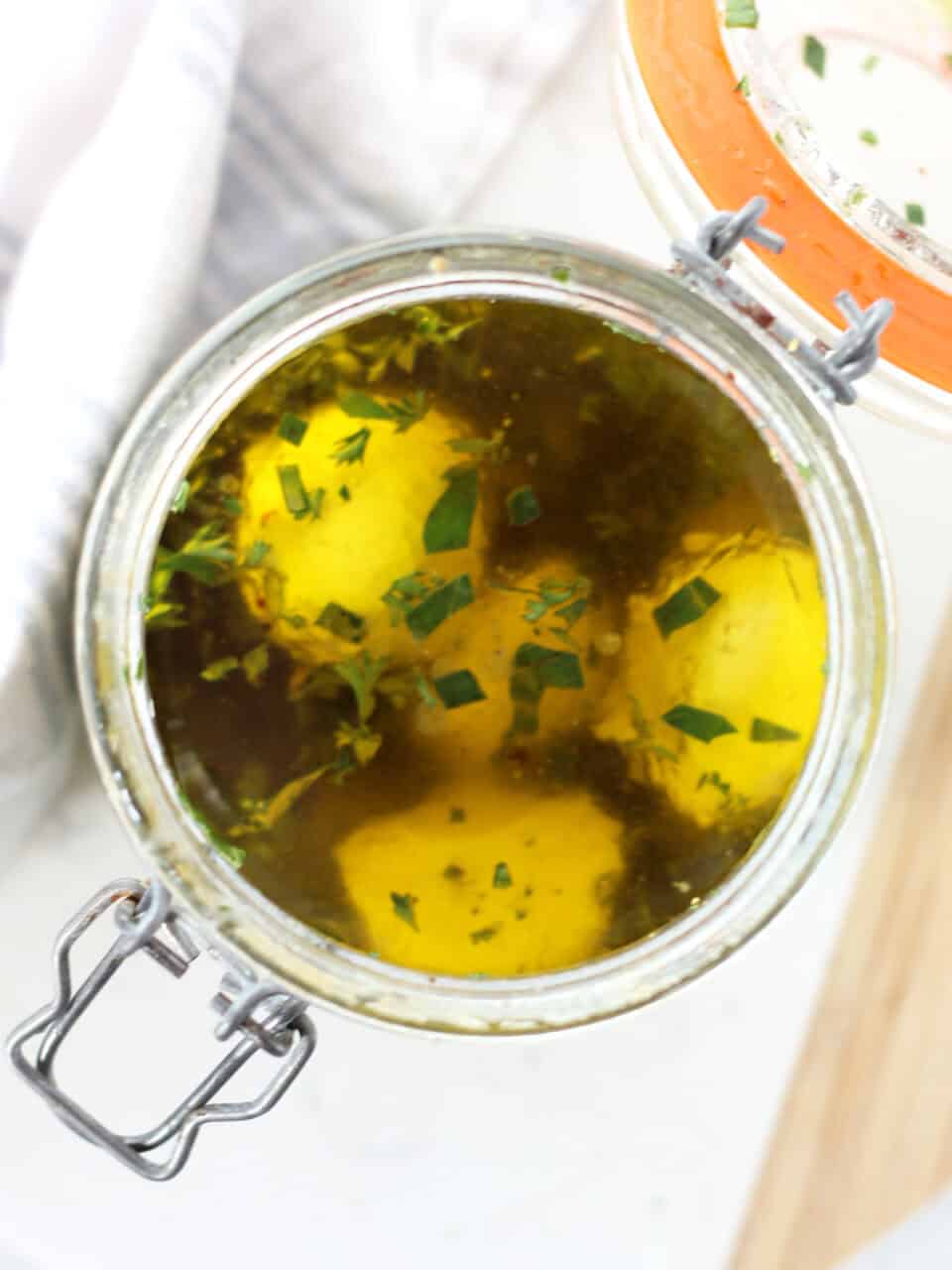 Marinating Bocconcini balls in a glass jar.