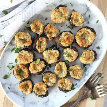 Blue cheese and mushroom appetizer served on a plate next to two forks.