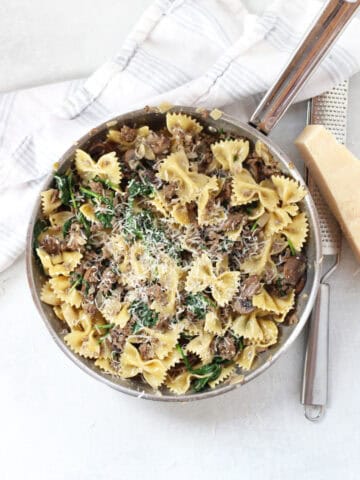 A skillet of beef, mushroom and spinach pasta.