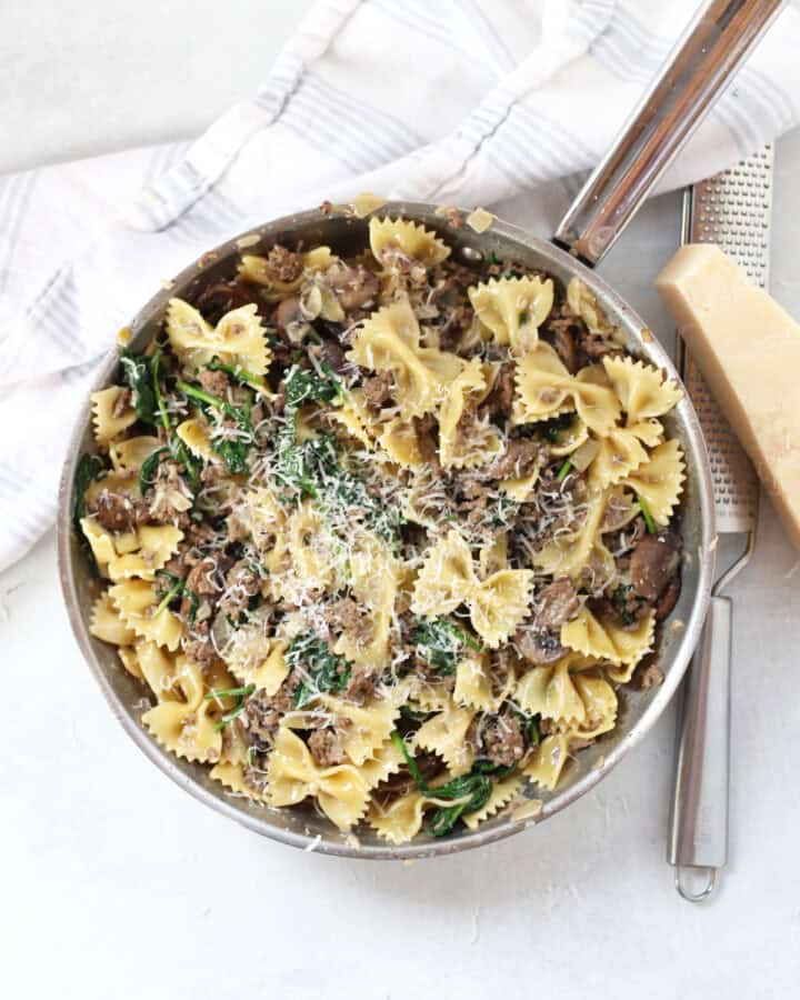 A skillet of beef, mushroom and spinach pasta.