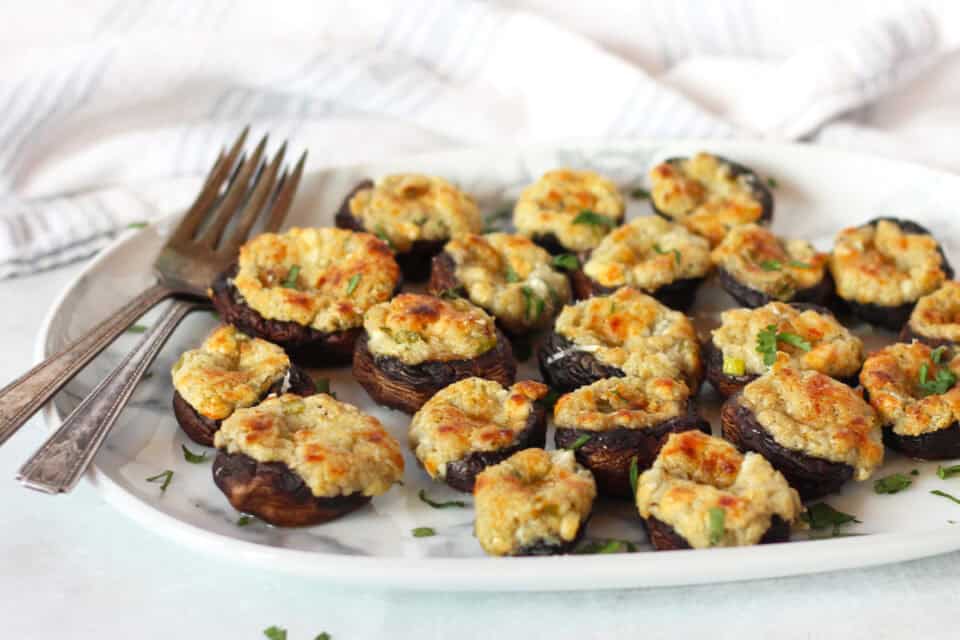 Blue cheese stuffed mushrooms on a serving plate with two small forks.