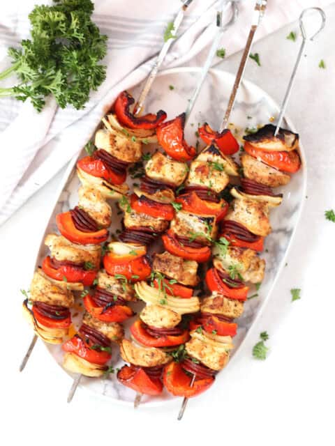 Four chicken chorizo kebobs on metal skewers.
