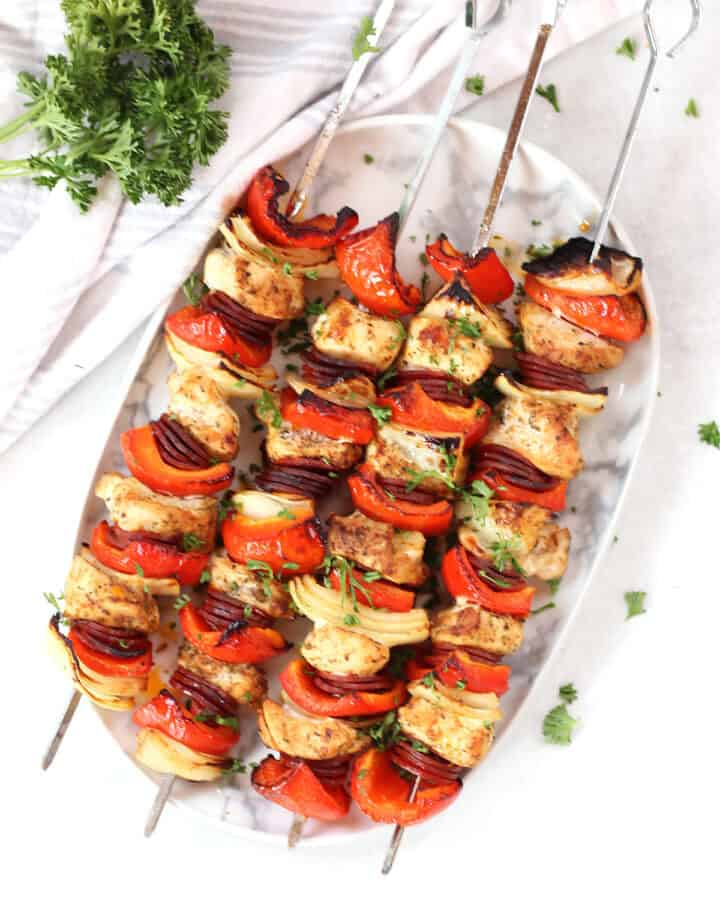 Four chicken chorizo kebobs on metal skewers.