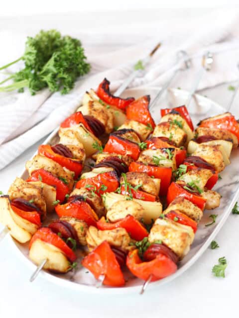 Four chicken chorizo skewers on a serving plate.